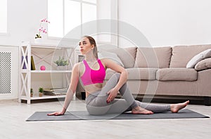 Woman training yoga in twisting sage pose.