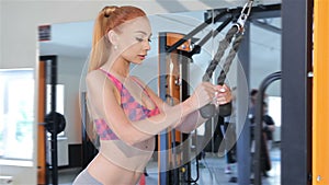 Woman trains her back and arm muscles on gym machine at the fitness centre