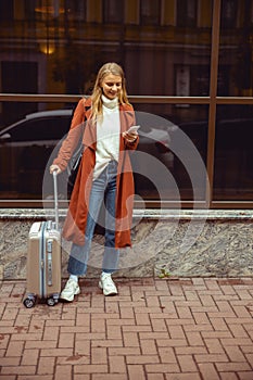 Woman with a travel bag standing outside