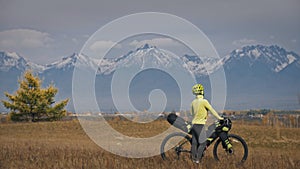 The woman travel on mixed terrain cycle touring with bikepacking. The traveler journey with bicycle bags. Sport tourism
