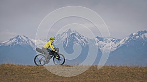 The woman travel on mixed terrain cycle touring with bikepacking. The traveler journey with bicycle bags. Sport tourism