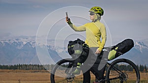 The woman travel on mixed terrain cycle touring with bikepacking. The traveler journey with bicycle bags. Sport tourism