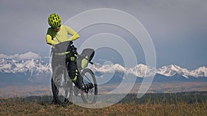 The woman travel on mixed terrain cycle touring with bikepacking. The traveler journey with bicycle bags. Sport tourism