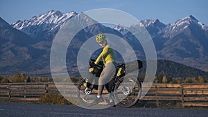 The woman travel on mixed terrain cycle touring with bikepacking. The traveler journey with bicycle bags. Sport tourism