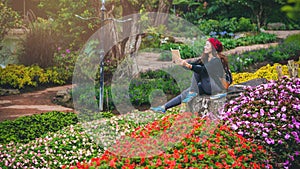 Woman travel nature in the flower garden. relax sitting on rocks and reading books In the midst of nature at national park doi