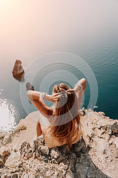 Woman travel sea. Happy tourist enjoy taking picture outdoors for memories. Woman traveler looks at the edge of the