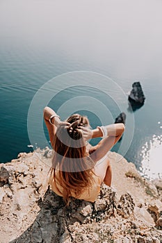 Woman travel sea. Happy tourist enjoy taking picture outdoors for memories. Woman traveler looks at the edge of the