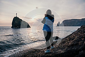 Woman travel sea. Happy tourist enjoy taking picture outdoors for memories. Woman traveler looks at sea bay of mountains