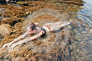 Woman travel sea. Happy tourist enjoy taking picture outdoors for memories. Woman traveler swim in the sea bay with