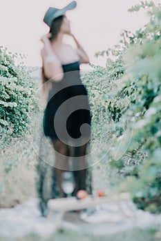 Woman travel winery. Portrait of happy woman holding glass of wine and enjoying in vineyard. Elegant young lady in hat