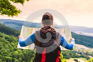 Woman traveler with backpack checks map to find directions in wi