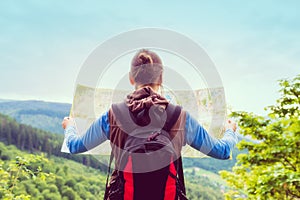 Woman traveler with backpack checks map to find directions in wi