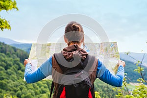 Woman traveler with backpack checks map to find directions in wi