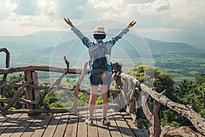 Woman traveler with backpack enjoying view and happy freedom at mountains