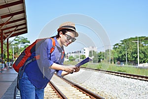 Woman traveler with backpack and hat looking the map at th