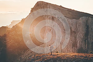 Woman Traveler with backpack hiking on cliff