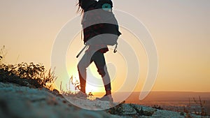 Woman traveler with backpack hiking in mountains. Silhouette hiker walking in the mountains, freedom and happiness
