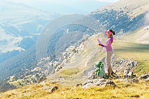 Woman traveler with a backpack and a map on the background of the Pyrenees mountains. Hiking and adventure concept