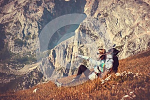Woman Traveler with Backpack relaxing in Mountains