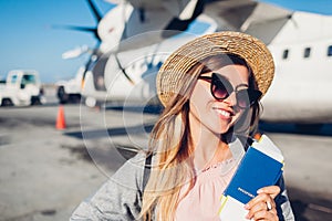 Woman traveler boarding on plane holding passport tickets. Happy passenger with backpack ready for flight