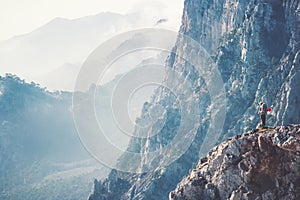 Woman Traveler on cliff hiking with backpack