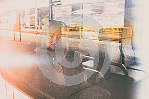 Woman traveler contemplating outdoor view from window of train. Young lady on commute travel to work sitting in bus or