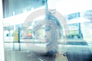 Woman traveler contemplating outdoor view from window of train. Young lady on commute travel to work sitting in bus or