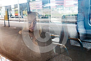 Woman traveler contemplating outdoor view from window of train. Young lady on commute travel to work sitting in bus or