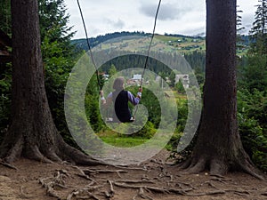 woman traveler enjoying of swinging on swing and mountain view