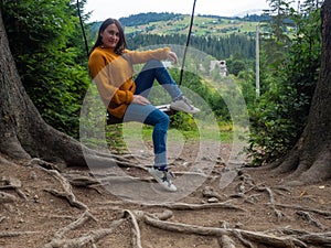 woman traveler enjoying of swinging on swing and mountain view