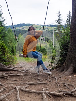 woman traveler enjoying of swinging on swing and mountain view