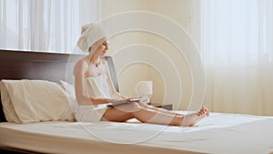 Woman traveler enjoying time in a comfortable hotel room with a modern device. Happy woman using laptop while relaxing