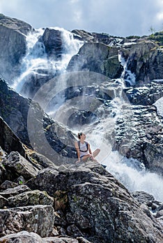 Woman traveler enjoying the view of Siklawa waterfall on a beautifull sunny day.