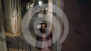 Woman traveler going stairs night city street. Girl walking upstairs empty lane.
