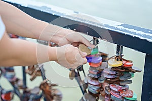 Woman Traveler hand lock key during travel in Da Nang. Tourist sightseeing at love lock bridge. Landmark and popular. Vietnam and