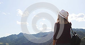 Woman traveler hiker admiring amazing view in mountains valley with river.