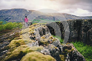 Woman traveler hiking across Iceland landscape.