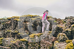 Woman traveler hiking across Iceland landscape.