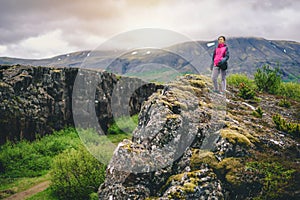 Woman traveler hiking across Iceland landscape.