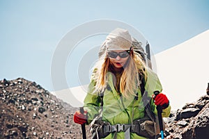 Woman traveler hiking in mountains with backpack