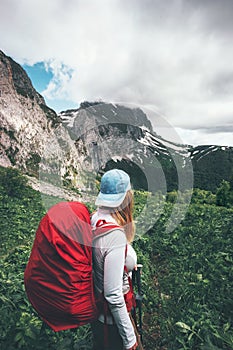 Woman traveler hiking in mountains with backpack