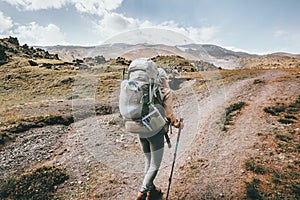 Woman traveler in mountains with big backpack