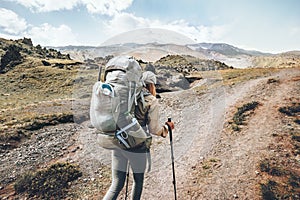 Woman traveler in mountains with big backpack