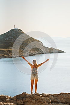 Woman traveler raised hands enjoying sea and lighthouse view travel healthy lifestyle active summer vacations outdoor