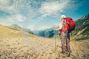 Woman Traveler with red backpack mountaineering