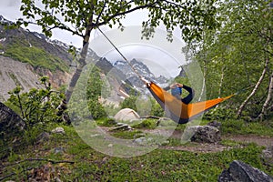 Woman traveler relaxing in hammock in the mountains