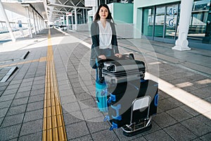 Woman traveler rolling luggage trolley outside