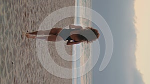 Woman traveler running beach enjoying summer vertically. Girl posing near ocean