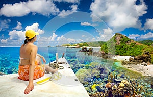 Woman traveler sails on a boat enjoying the coral reef around is