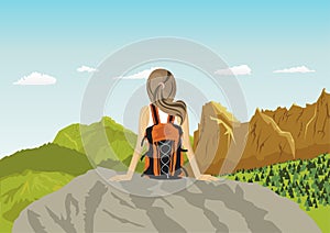 Woman traveler sitting on rocks looking at mountains